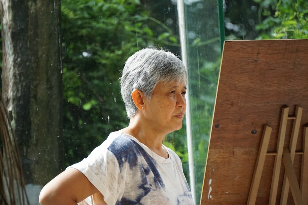 elderly woman smiling while painting